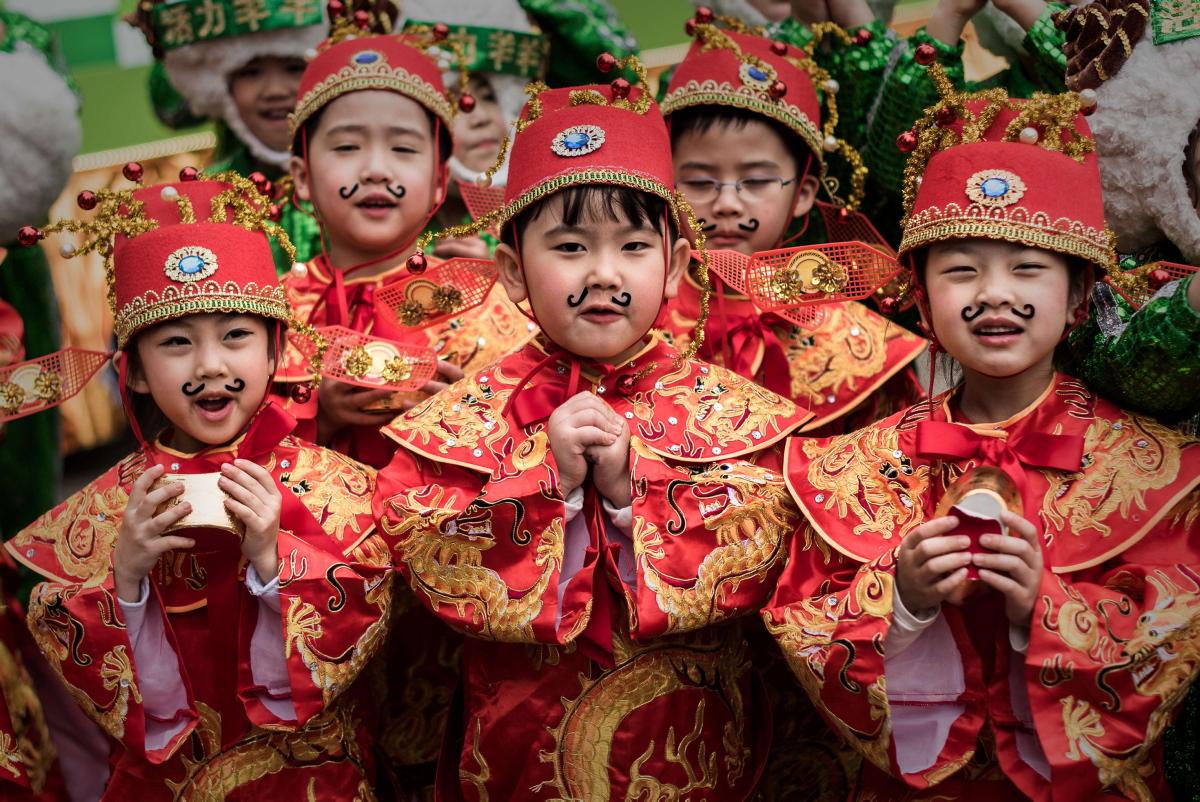 Китайские дети в красных нарядах на праздновании Нового Года