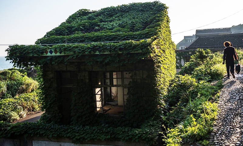 Турист гуляет по деревне Houtou Wan